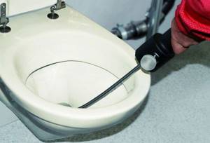 Cleaning the toilet with a cable