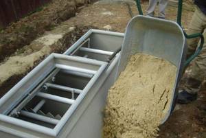 Photo: the final stage of installation - backfilling the septic tank in the pit