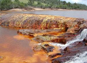 Hydrothermal spring with ferruginous water. Iron oxides color water brown. 