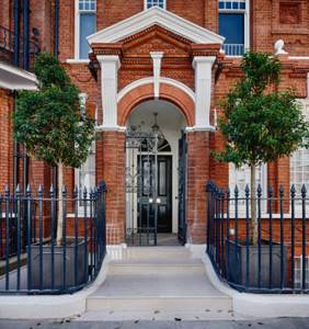 Forged fence in front of the main entrance of a brick mansion