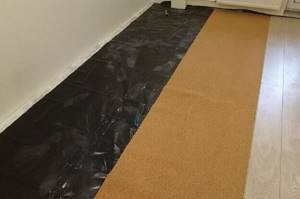 Laminate lays on the floor with a vapor barrier and a cork backing