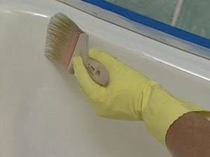 Applying paint to a bathtub with a brush