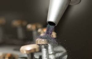 Sandblasting is a mechanical action on the surface of small solid particles
