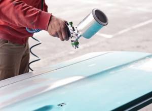 Painting car parts with a spray gun.