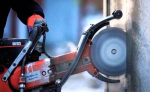 Working with an angle grinder with a diamond wheel attachment