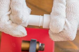 Plumber in gloves connects heated pp pipes