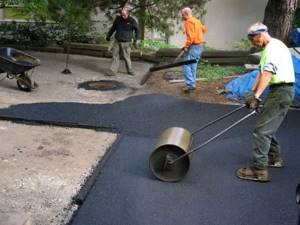 Laying cold asphalt with a manual roller