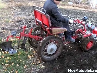 Plowing the land with a walk-behind tractor with an adapter